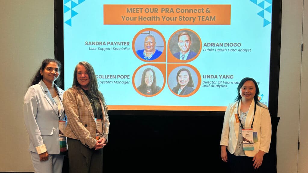 Smiling team members standing in front of presentation.