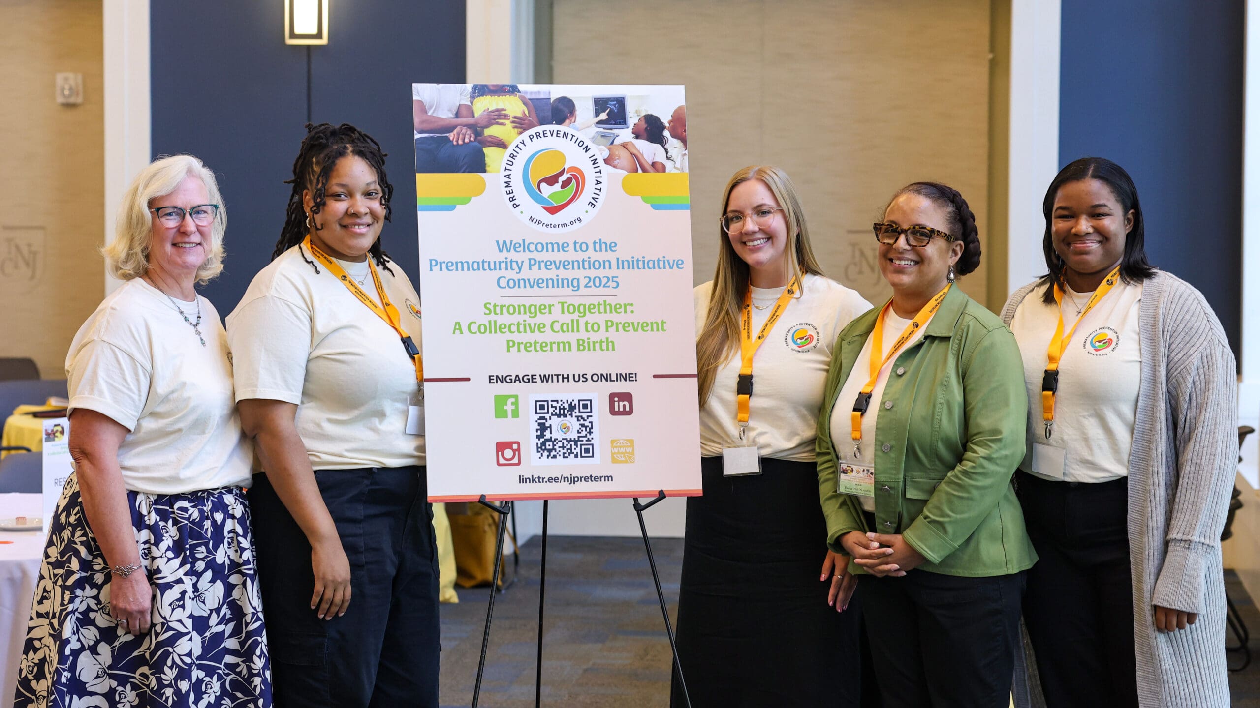 PPI team standing near presentation board at Convening.